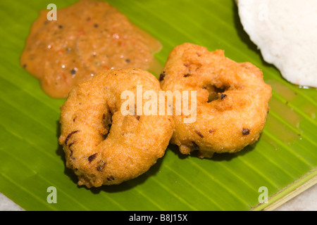 Indien Tamil Nadu Kumbakonam südwärts Inder Frühstück zwei Vadai mit würzigen Sambar serviert und Chutney auf Banane Blatt Teller serviert Stockfoto