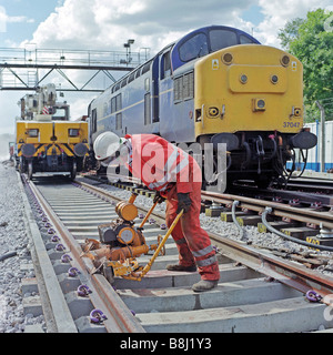 Auftragnehmer mit Sondermaschine Schiene leicht Schleifen Schweißnähte um glatte Oberflächen zu gewährleisten, wo die Strecke verbunden ist. Stockfoto