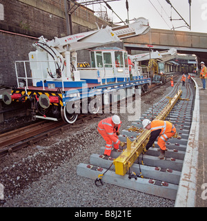 Selbstfahrende Twin-Jib Schiene Kran hebt Betonschwellen in Position am Hauptbahnhof während einer Track-Erneuerungsprogramm. Stockfoto