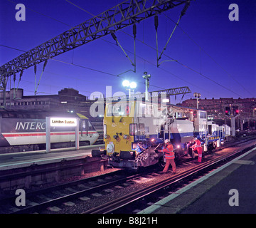 Auftragnehmer Vorbereitung ein Vorschaltgerät Stopfen Maschine für Arbeiten an neu installierten Nacht verfolgen, während ein Upgrade-Programm. Stockfoto