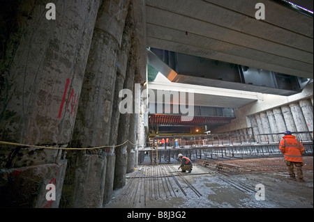 In den Schatten gestellt durch riesige aufgetürmt Betonwände, untersuchen Ingenieure verstärkten Fußboden während der St Pancras Rekonstruktion auf die Strg-Taste Stockfoto