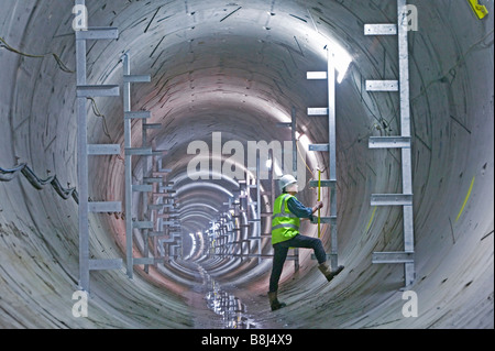 Ingenieur untersucht neu installierte Klammern, welche die permanente Ausstattung in diesem Tunnel macht Kabel installiert werden vornimmt. Stockfoto