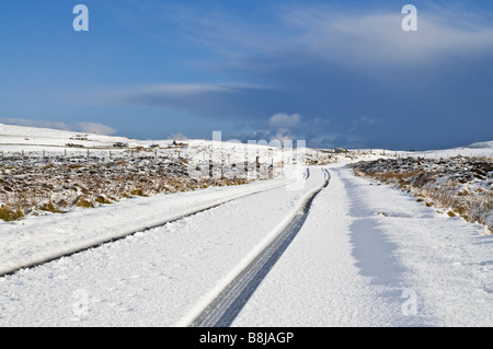 dh ROADS UK Scotland eisig verschneite Straßen Schneefelder Reifen Verfolgt die Wintermarkierungen von Orkney auf der offenen Landstraße Stockfoto