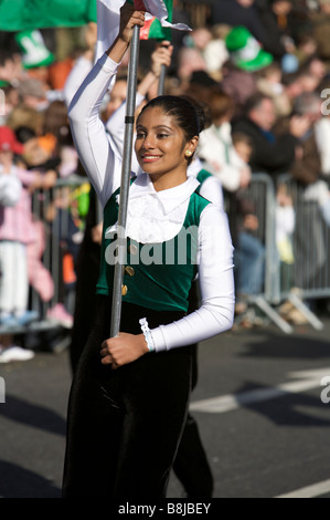 Ein Teilnehmer um die Menge in der St. Patricks Day Parade in Dublin Irland lächelt, wie sie einen Banner trägt Stockfoto