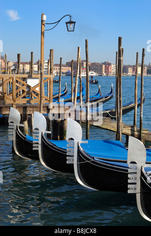 Der Bug der vier Gondeln vor Anker in einer Linie am Pier auf der Lagune in der Nähe von Markusplatz entfernt, Venedig. Stockfoto