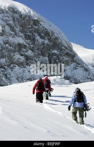 Eine Gruppe von Menschen zu Fuß auf den Berg mit ihren Snowboards in Nassfeld, Österreich Stockfoto