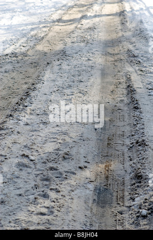 Kleine Straße mit schmutzigem Schnee bedeckt. Stockfoto