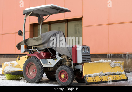 Schnee-Reinigung Mini-Traktor in der Nähe Gebäude geparkt. Stockfoto