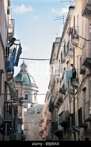 Frauen hängen Wäsche in einer Straße mit Blick auf die Cattedrale di San Lorenzo, Trapani, West-Sizilien, Italien Stockfoto