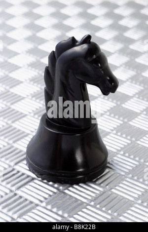 Einsame schwarze Ritter auf metallic-Muster Hintergrund stehend Stockfoto