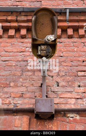 Alten gebrochenen Laterne mit zerbrochenen Lampe über roten Backsteinmauer. Stockfoto
