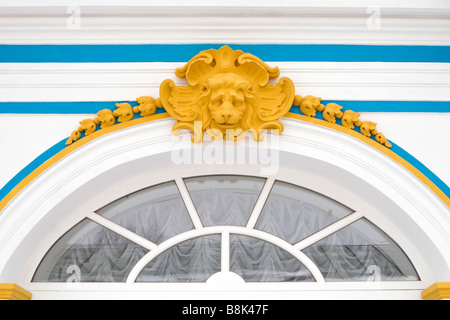 Russischen Palast Löwenkopf Wand Dekoration gelb Basrelief über gewölbte Fenster. Stockfoto