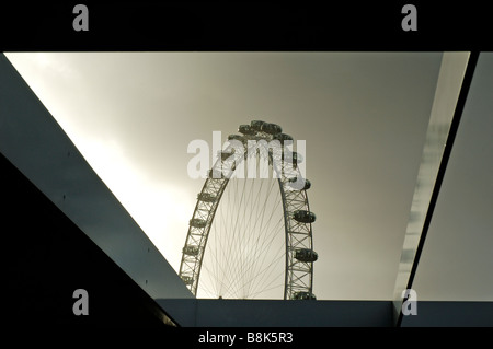 Das London Eye, gesehen von der South Bank eingerahmt von Architektur Stockfoto