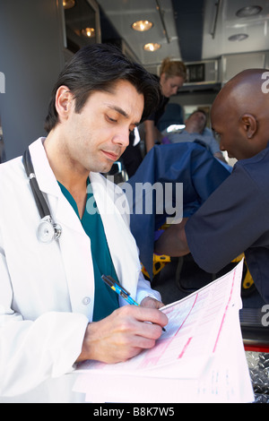 Arzt, Notizen, wie Sanitäter Patienten entladen Stockfoto