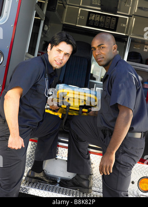 Zwei Sanitäter fröhlich entfernen leere Bahre von Ambulanz Stockfoto