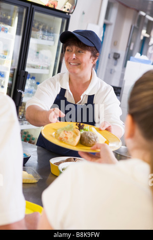 Schüler mit Mittagessen im Speisesaal Stockfoto