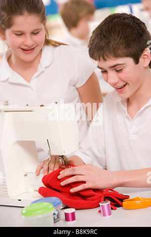 Männliche und weibliche Studenten mit Nähmaschine Stockfoto