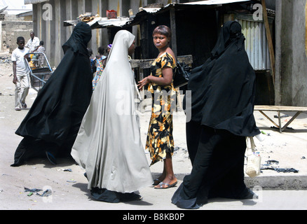 Ein skeptiker Suchen modern gekleidet christliche Frau in muslimischen Frauen das Tragen einer Burka. Maiduguri, Borno State, Nigeria Stockfoto