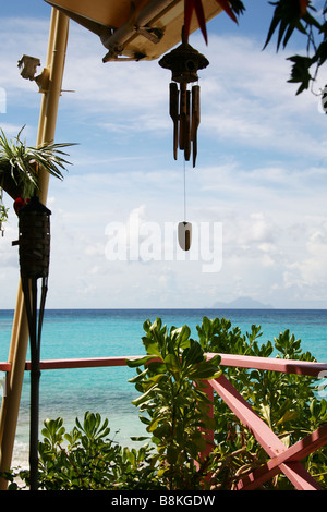 Blick von einer Veranda über einem paradiesischen Strand mit einem schönen blauen Himmel, weiße Wolken und Azur Meer. Typische Einstellung für die Karibik Stockfoto