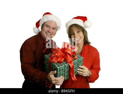 Ein süßes Erwachsenen paar Santa Hüte trägt und hält ein Weihnachtsgeschenk isoliert auf weiß Stockfoto
