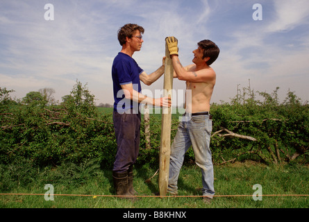 Botton Dorf für Menschen mit Lernbehinderungen, North Yorkshire. Zwei Community-Mitglieder setzen sich in einen neuen Zaunpfosten. Stockfoto