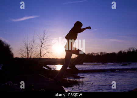 Mann springt über Felsen auf dem James River in Richmond, Virginia. Stockfoto