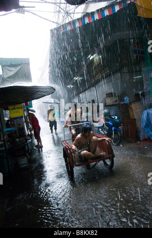 Menschen, die gefangen in Monsun-Regen in Gasse Chinatown zentrale Bangkok Thailand Stockfoto