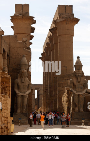 Touristen in das große Gericht von Ramses II stand unter zwei kolossale Statuen und Kolonnade von Amenhotep III, Luxor-Tempel, Ägypten Stockfoto