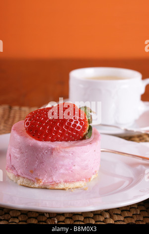 Frische Erdbeer Torte mit halben Frucht auf der Oberseite und eine Tasse heißen cappuccino Stockfoto