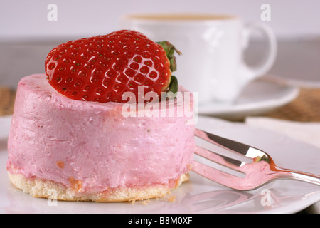 Frische Erdbeer Torte mit halben Frucht auf der Oberseite und eine Tasse heißen cappuccino Stockfoto