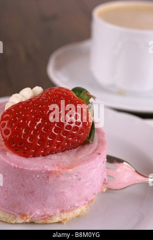 Frische Erdbeer Torte mit halben Frucht auf der Oberseite und eine Tasse heißen cappuccino Stockfoto