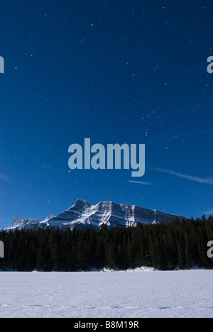 Nachtansicht von einem zugefrorenen Johnson-See im Banff Nationalpark, Alberta, Kanada. Stockfoto