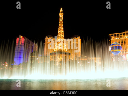 Bellagio Fountains mit Paris und Caesars Casino & Hotel im Hintergrund in der Nacht auf den Las Vegas strip, Nevada, USA Stockfoto