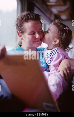 Mutter Tochter, Tochter Mutter Wange küssen lesen Stockfoto