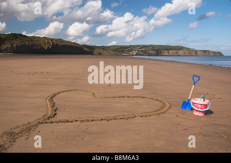 Herz im Sand an Robin Hoods Bay/Boggle Loch in North Yorkshire Stockfoto