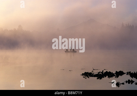 Sonnenaufgang am See Cassidy und Mount Pilchuck im Nebel mit Silhouette Fischer in kleines Ruderboot Gießen seine Linie Stockfoto