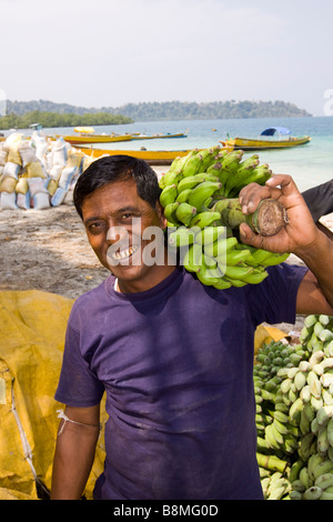 Indien-Andamanen und Nikobaren Havelock Insel Nummer 1 Strand Mann laden grüne unreife Bananen Stockfoto