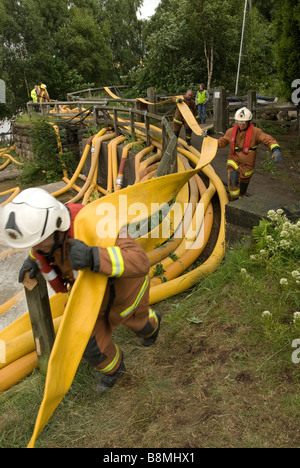 Feuerwehrleute legen Sie hohe Volumen Pumpen Schlauch um Hochwasser zu entfernen Stockfoto