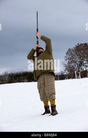 Mann in traditioneller Kleidung schießen hohe fliegende Fasan mit 12 Bohrung Schrotflinte Cumbria Stockfoto