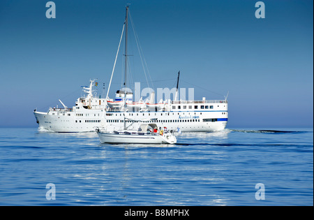 Passagierschiff vorbei ein Segelboot auf dem offenen Meer Stockfoto