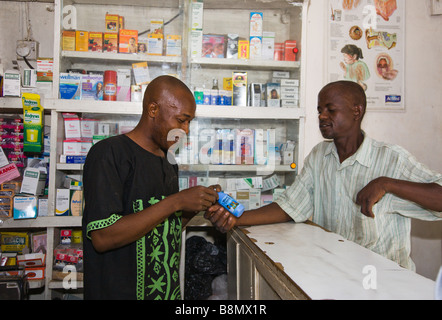 Eine patent geschützten Medizin-Anbieter (PPMV) in Kano, Nigeria zeigt einem potenziellen Kunde eine Flasche von Waterguard. Stockfoto