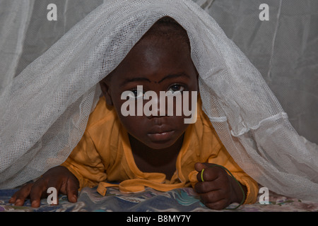 Ein Kind in der Gegend von Abuja, unter einer lang anhaltenden Insektizid Permanet lugt bereits behandelt Moskitonetz. Stockfoto