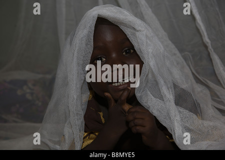 Ein Kind in der Gegend von Abuja, unter einer lang anhaltenden Insektizid Permanet lugt bereits behandelt Moskitonetz. Stockfoto