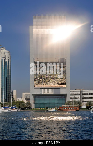 Dubai Creek und moderne Architektur Skyline mit geschwungener Front Der National Bank of Dubai und Sonne, die aus dem Glas aufflackernde Vereinigte Arabische Emirate VAE Stockfoto