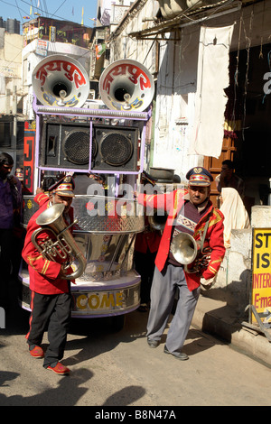 indische Bandmitglieder ziehen traditionelle öffentliche Adresse Anhänger durch die Gassen von Udaipur während eine Puja-Zeremonie Stockfoto