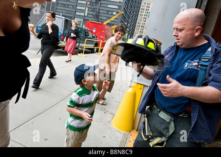 Junge im Gespräch mit Feuerwehrmann außerhalb New York City Fire Department. Stockfoto