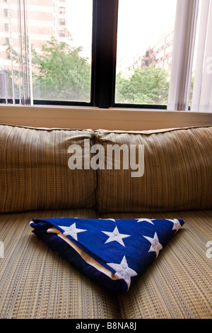 Innenansicht Wohnung am 93. Street mit einer gefalteten USA Nationalflagge prominent auf einem Sofa liegend Stockfoto