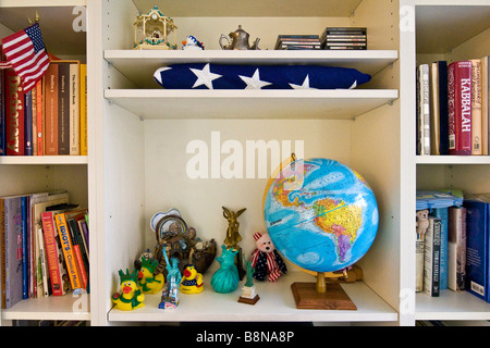 Ornamente auf einem Regal in einer Wohnung am 93. Street mit einer gefalteten Nationalflagge USA Stockfoto