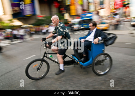 Business-Mann eine Fahrt in einer Rikscha oder mit dem Fahrrad Taxi am Times square Stockfoto