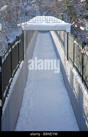 Fußgängerbrücke über die Bahnlinie, alles mit Schnee bedeckt Stockfoto